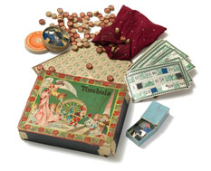 Ein altes Tombola-Spielset mit einer verzierten Schachtel, Spielkarten, kleinen nummerierten Holzplättchen, einem Beutel und anderen ausgestellten Spielfiguren.