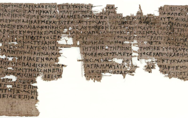 Fragment eines altgriechischen Papyrusmanuskripts mit handgeschriebenen Zeilen in schwarzer Tinte; Teile des Papyrus fehlen und sind ausgefranst.