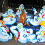 Sieben ausgeschnittene Cartoon-Geister, die jeweils unterschiedliche Gegenstände halten und als Vertreter verschiedener Berufe oder Hobbys gekleidet sind, sind auf einem blauen Sitz angeordnet.