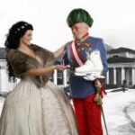 Eine Frau in einem historischen Kleid gestikuliert in Richtung eines Mannes in einem Kostüm mit Orden und Federhut, der einen modernen weißen Stiefel vor einem schwarz-weißen Hintergrund hält.