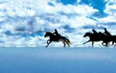 Silhouetten von drei Menschen, die auf Pferden durch eine verschneite Landschaft unter einem teilweise bewölkten Himmel reiten.