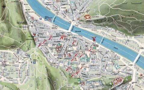 Illustrierter Stadtplan mit Straßen, Sehenswürdigkeiten und einem Fluss, der durch das Zentrum fließt, mit nummerierten Orten in der gesamten Region.