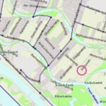 Eine detaillierte Straßenkarte, die ein Gebiet in Wien in der Nähe der Donau hervorhebt, wobei ein roter Kreis einen bestimmten Ort markiert. Straßen, Wasserwege und Parks sind beschriftet.