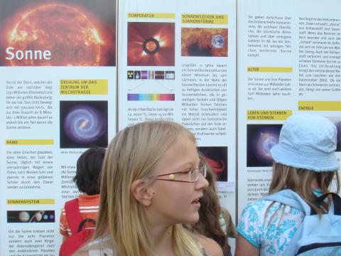 Eine Gruppe von Kindern sieht sich ein Plakat an.